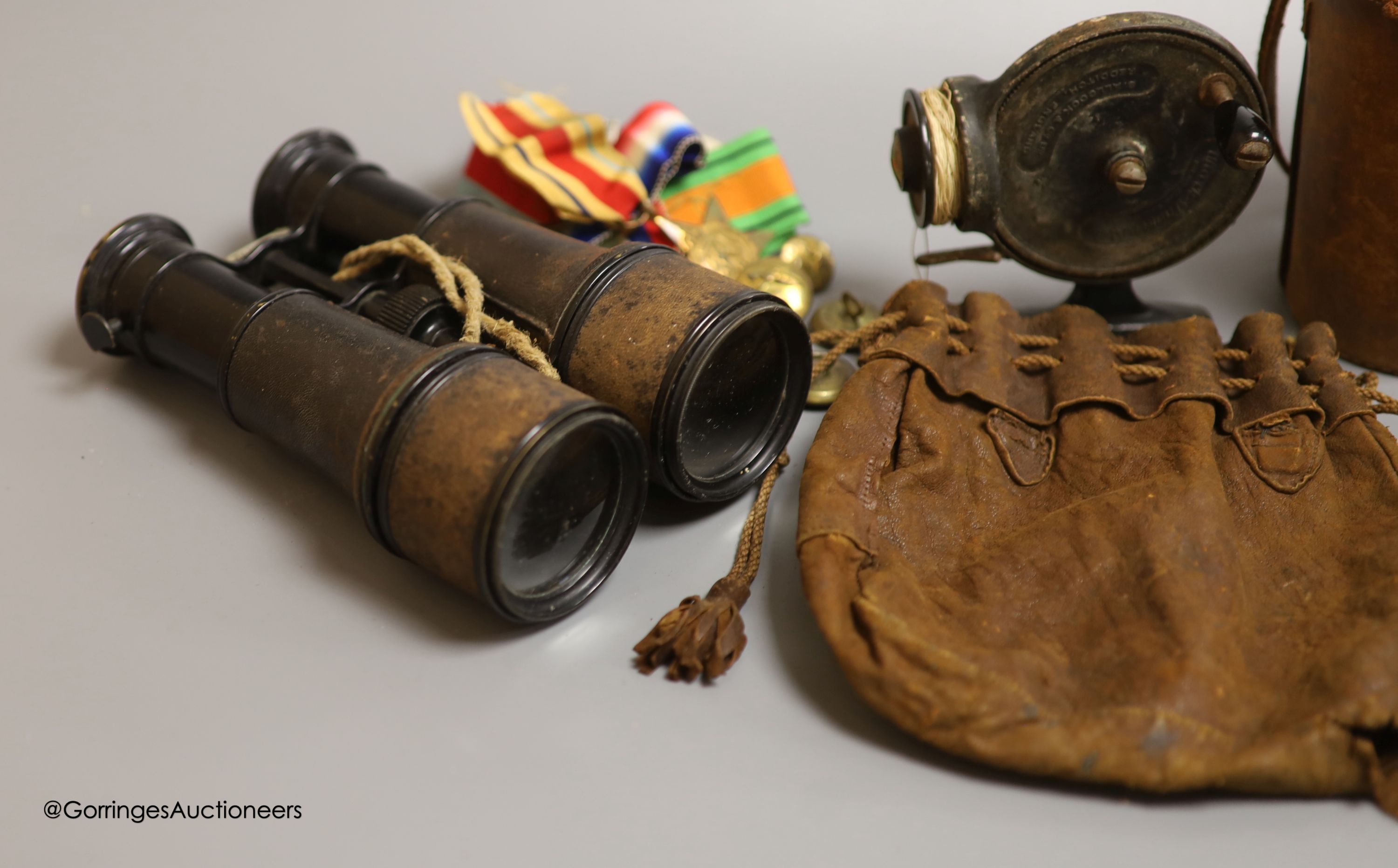 A leather cased flask and cups, various WWI and WWII medals, binoculars and a fishing reel